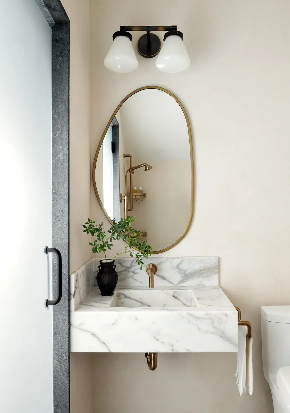 Marble vanity with brass fixtures designed by Lennon Nora Interior Design