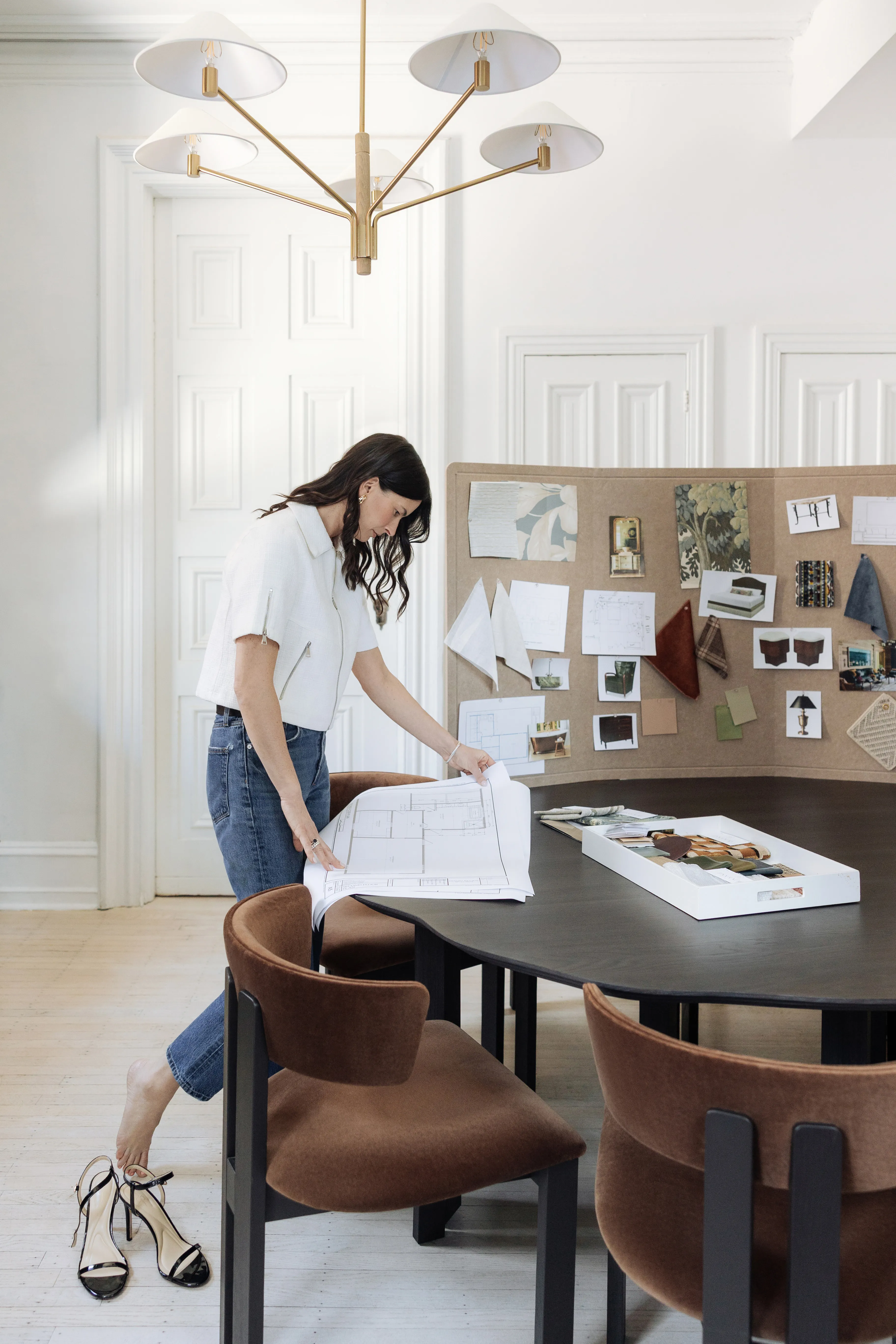 Interior designer reviewing floor plans at studio table with mood board