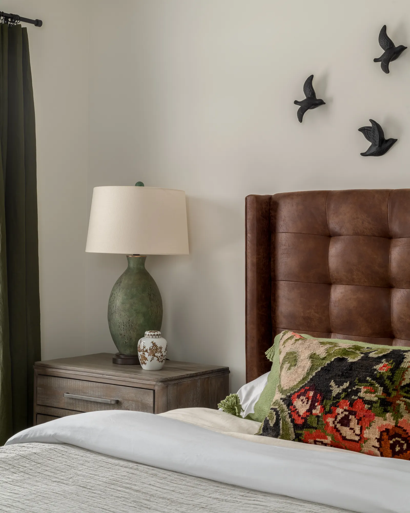 Green curtain guest nightstand with bird figurines