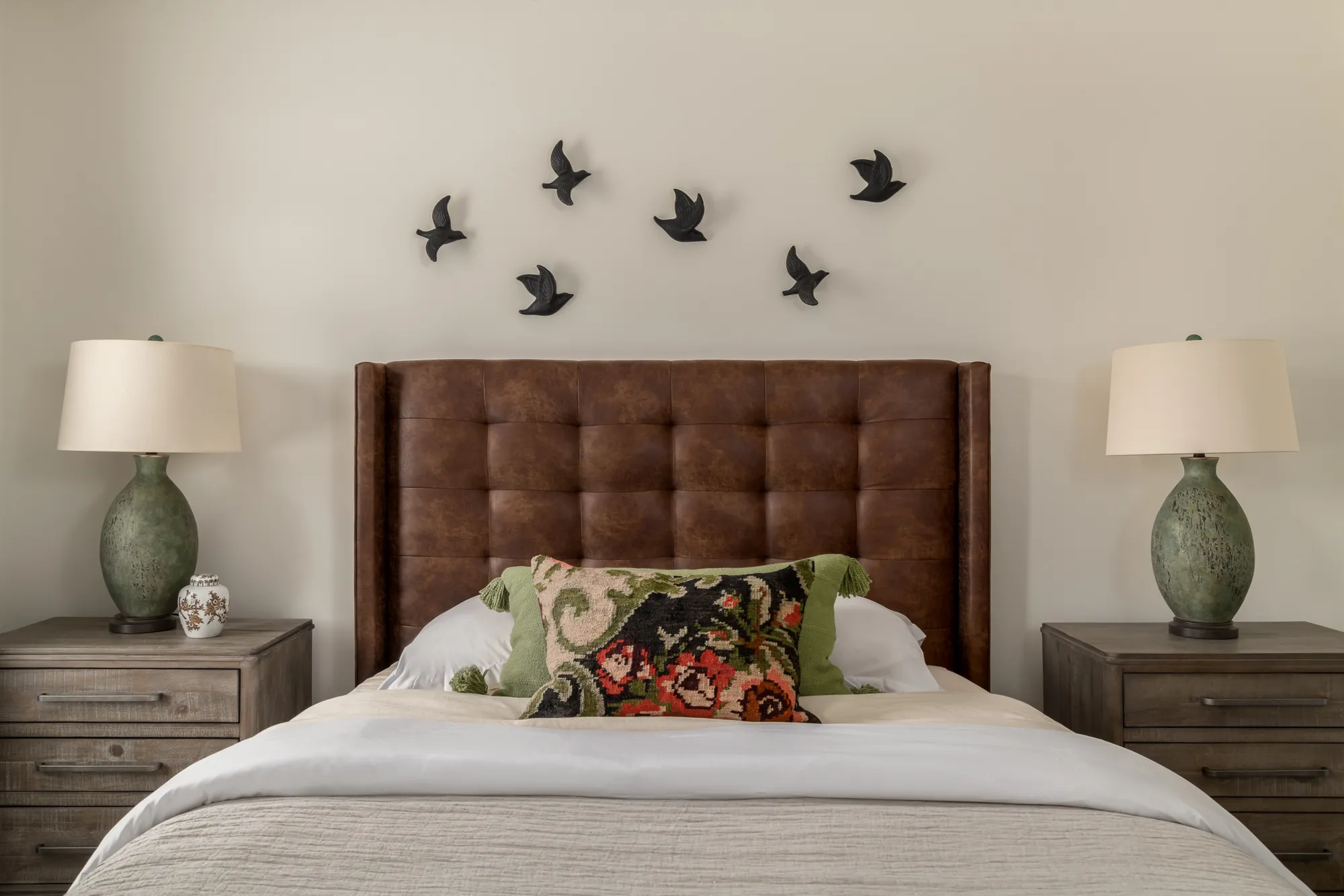 Guest bedroom with symmetric pillows and green drapery