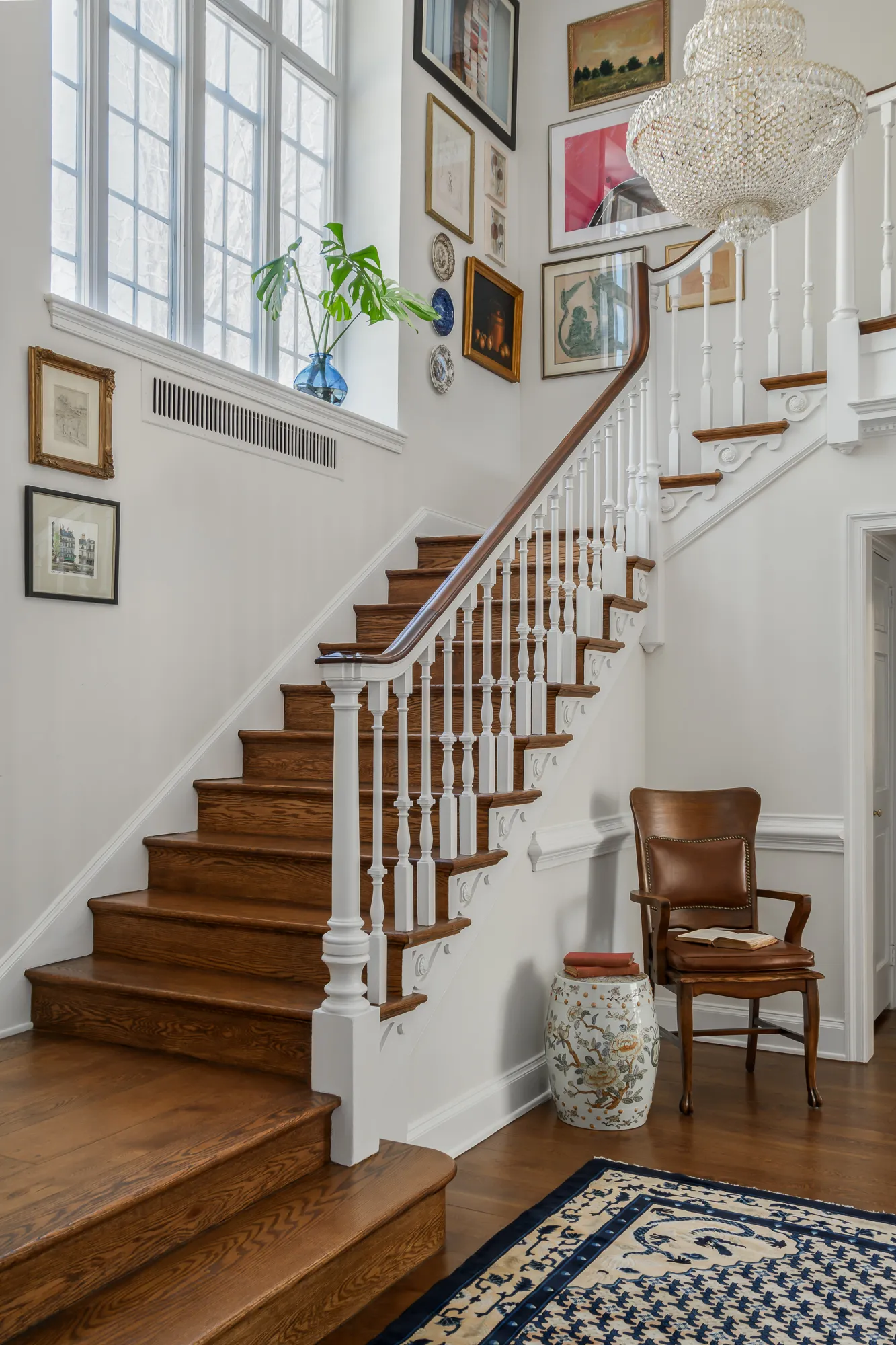 Two-story foyer with gallery wall, beaded chandelier, and Chinese garden stool
