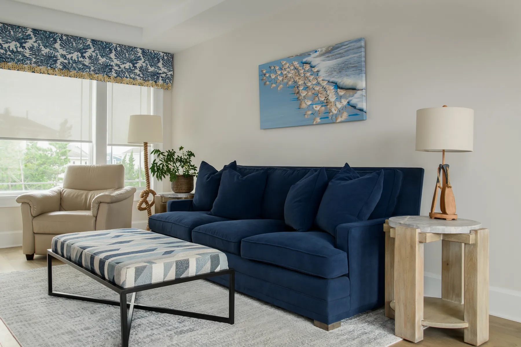 Navy velvet sofa with shorebird canvas and geometric upholstered bench