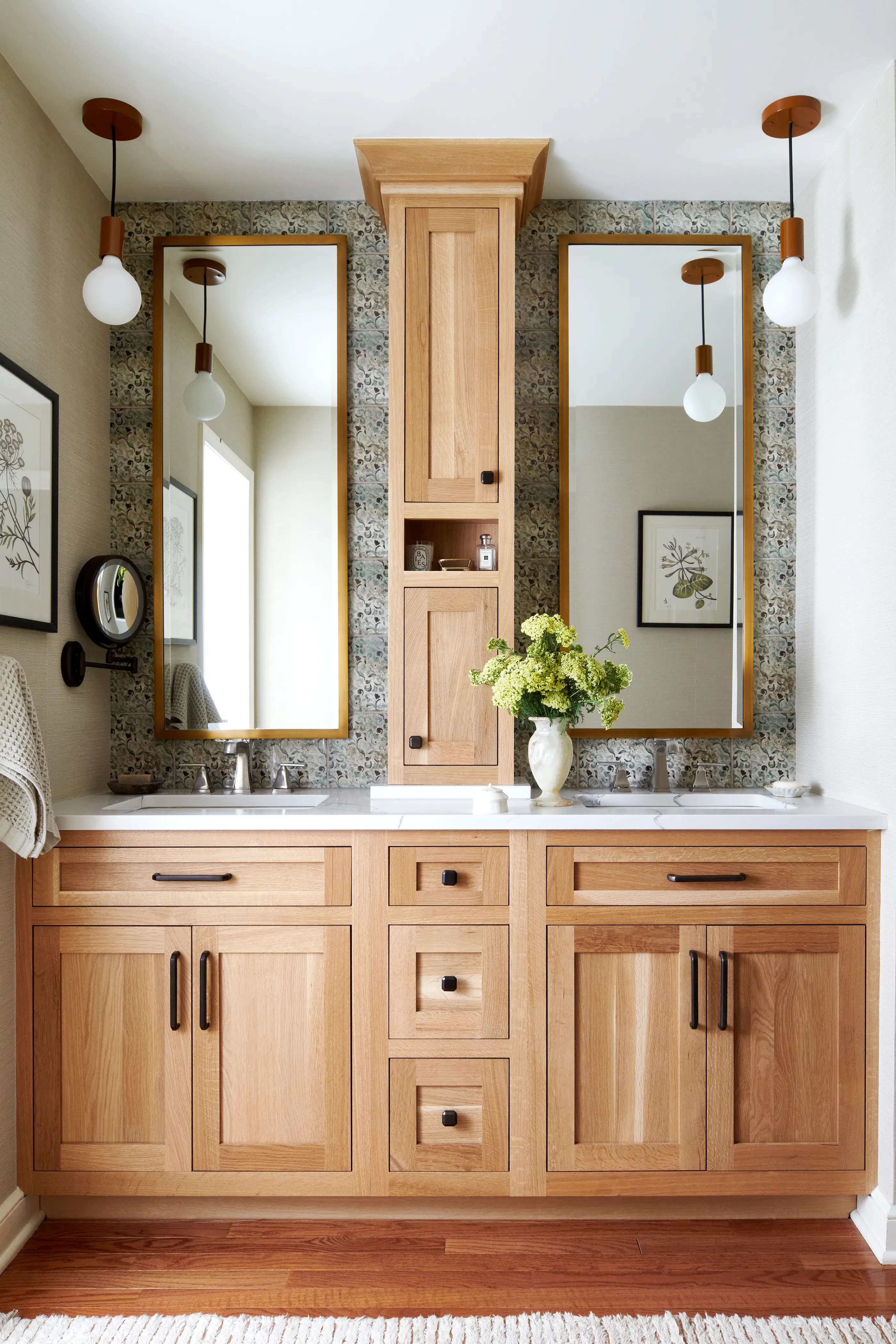 Double vanity bathroom with natural oak cabinetry, patterned tile backsplash, and wood pendant lights