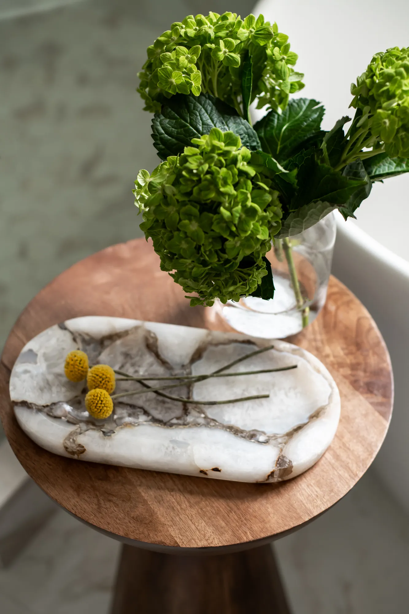 Walnut side table with green hydrangeas and marble tray